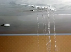 Emergency plumber repairing burst pipe under kitchen sink in Luton